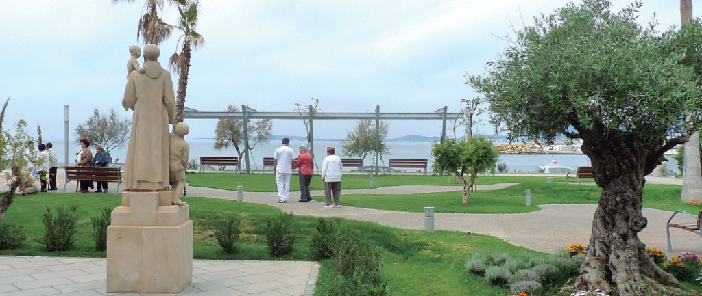 Unos pacientes pasean con sus cuidadores y familiares por los jardines de Sant Joan de Déu.